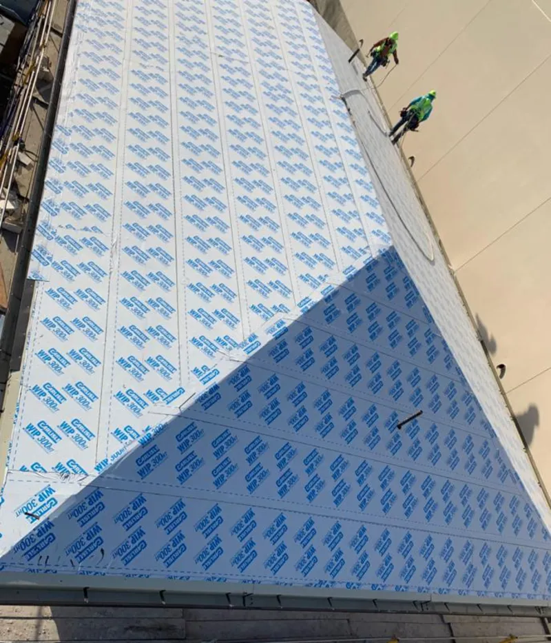 Professional roofers installing underlayment on a metal roof in Palm Coast